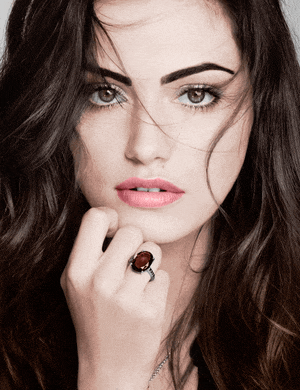 a close up of a woman 's face with a ring on her left hand