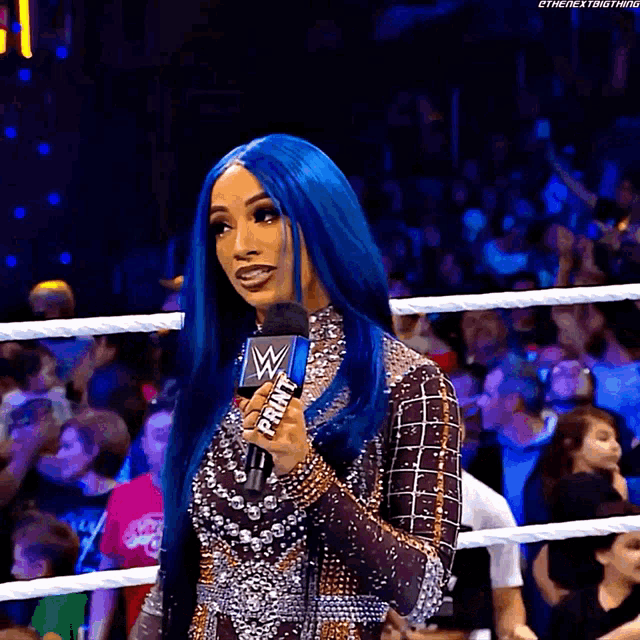 a woman with blue hair is holding a microphone that says print on it .