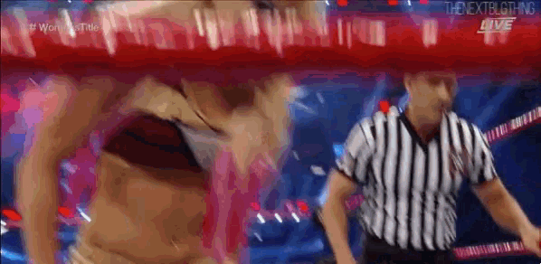 a woman is standing in a ring with a referee .