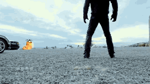 a man standing on a gravel road with chinese writing