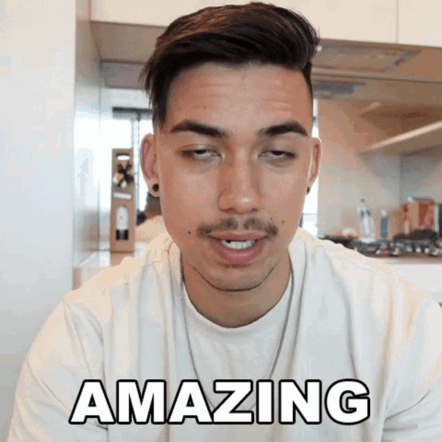a man in a white shirt is making a funny face and the word amazing is on the screen