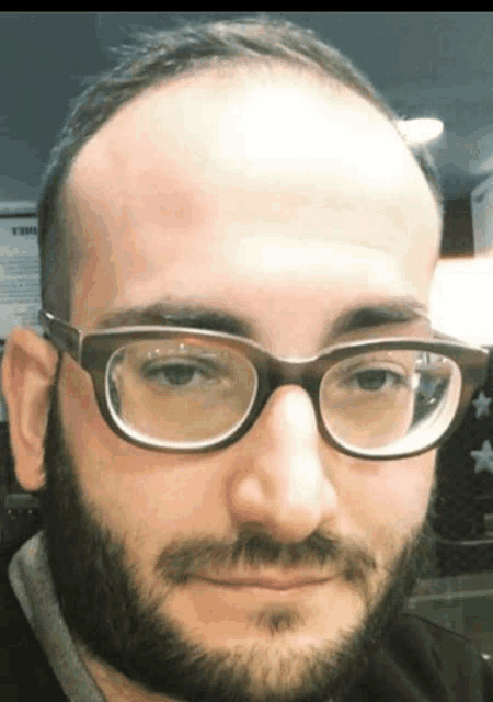 a man with a beard wearing glasses and a bald head