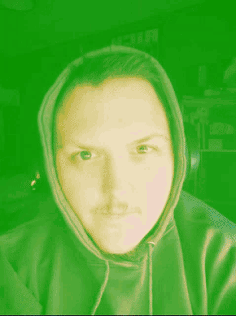 a man wearing a red hoodie looks at the camera with a red background
