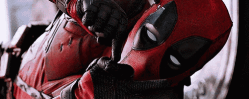 a close up of a person in a deadpool costume holding a gun .