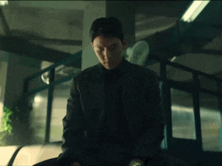 a man in a suit is sitting in a dark room .