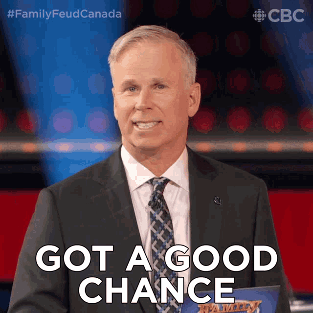 a man in a suit and tie is holding a sign that says got a good chance
