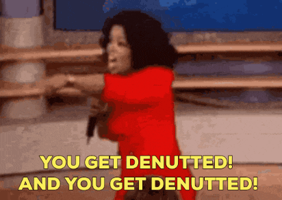 a woman in a red dress is holding a microphone and saying you get denutted and you get denutted