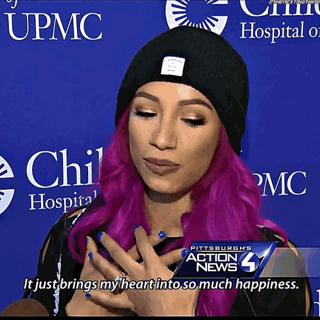 a woman with purple hair and a black hat says " it just brings my heart into so much happiness .. "