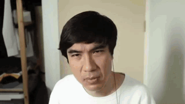 a man wearing headphones is making a funny face while sitting in a room .