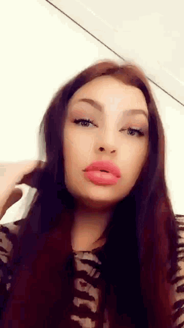 a close up of a woman 's face with red lips and a zebra print shirt .