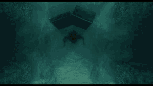 a person laying on a table in a dark room with a box that says ' a ' on it