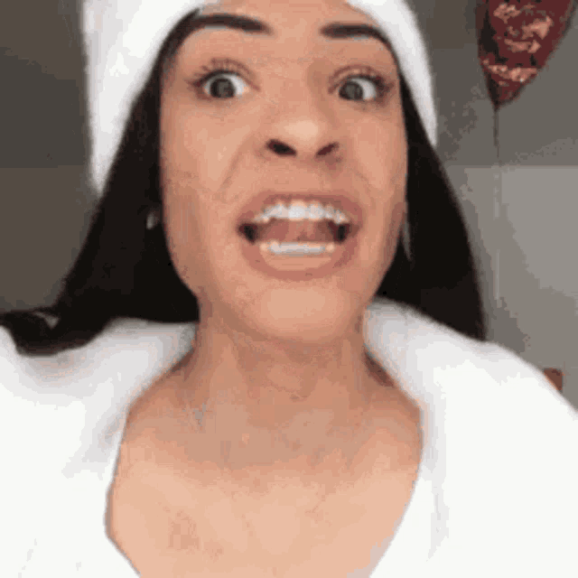 a woman wearing a white hat and a white shirt is smiling .