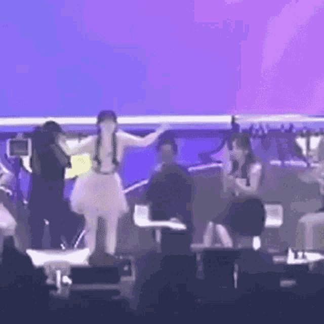 a group of women are dancing on a stage .
