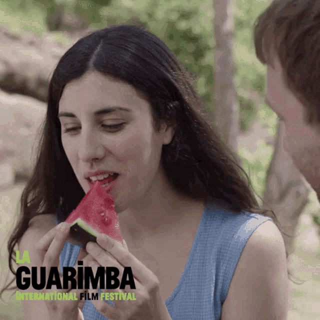 a woman eating a slice of watermelon with guarimba international film festival