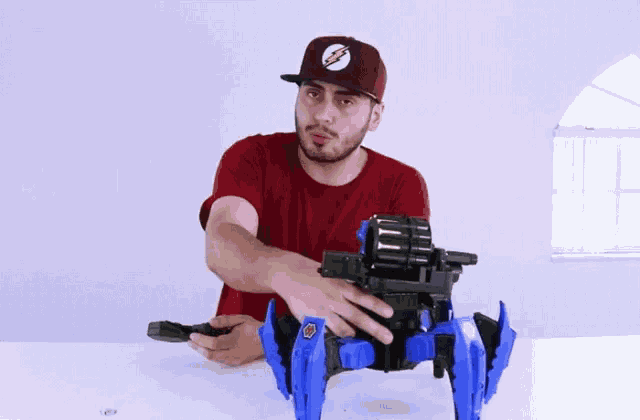 a man in a red shirt is playing with a toy robot .
