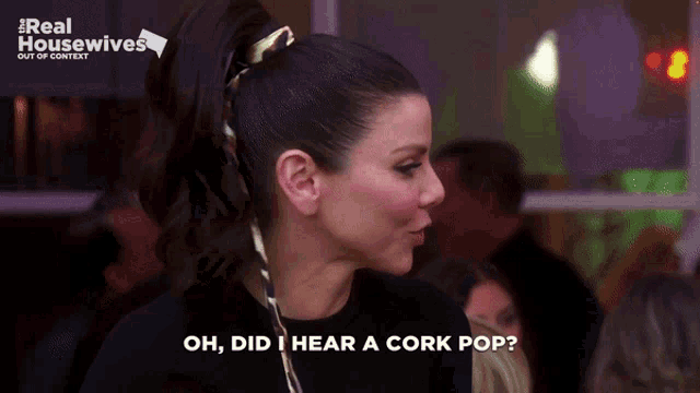a woman says oh did i hear a cork pop in front of a crowd