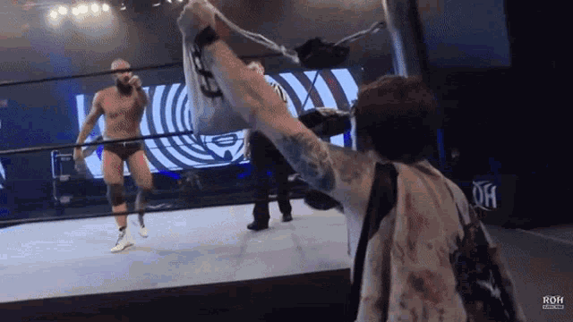 a man in a wrestling ring with the word roh on the back