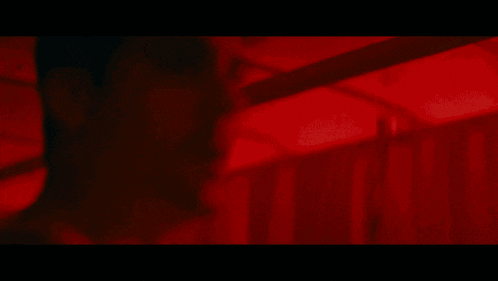 a blurred image of a person 's face with a red curtain behind them