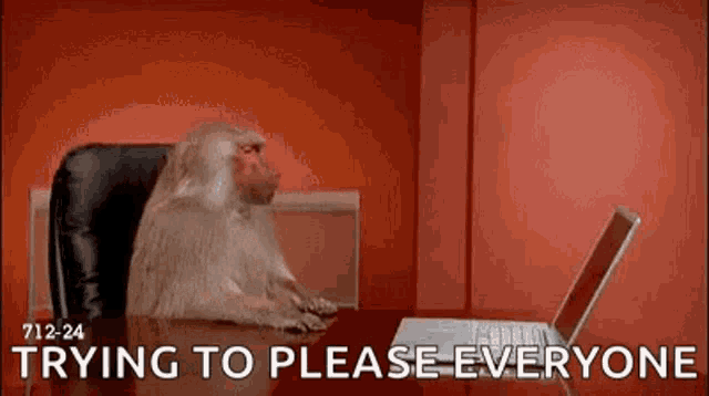a monkey is sitting at a table using a laptop computer .