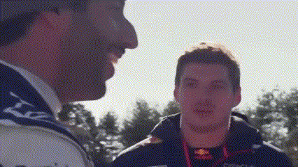two men are standing next to each other and talking .