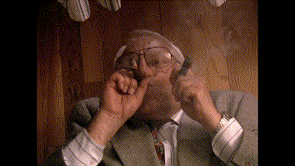 a man in a suit and tie is smoking a cigarette