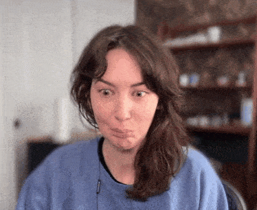 a woman wearing a blue sweatshirt making a face