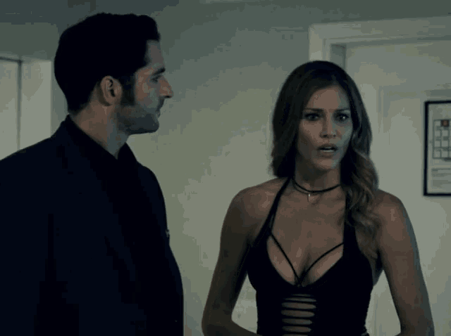 a man and a woman are standing next to each other in front of a door