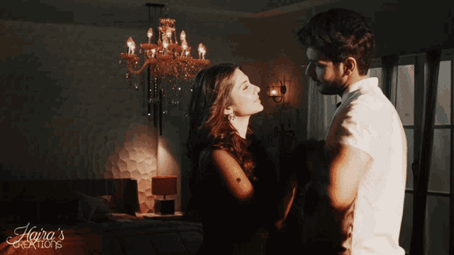 a man and woman are dancing in a room with a chandelier and the words aora 's creations on the bottom