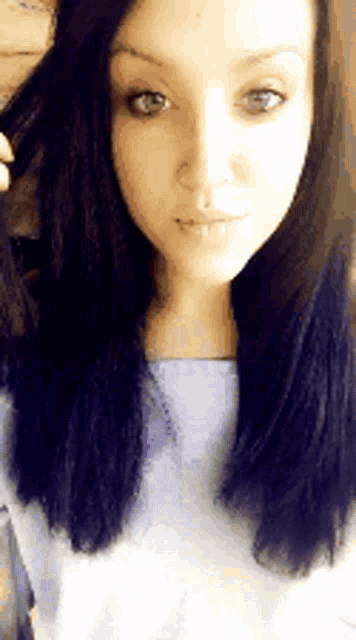 a close up of a woman 's face with blue hair