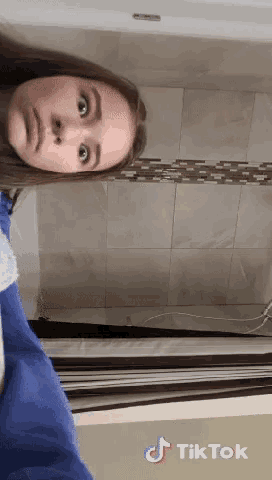 a girl is taking a selfie in a bathroom with a tiktok watermark