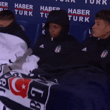 a group of people sitting in front of a banner that says haber turk on it
