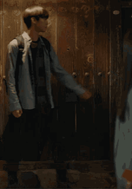 a man standing in front of a wooden door
