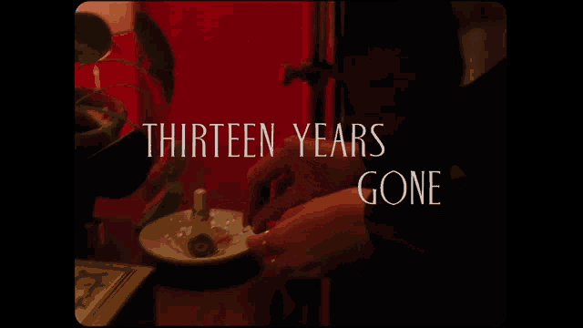 a thirteen years gone poster with a person holding a ring