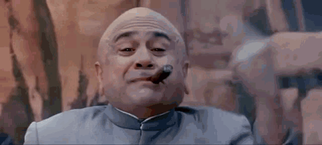 a bald man is smoking a cigar while wearing a blue suit .