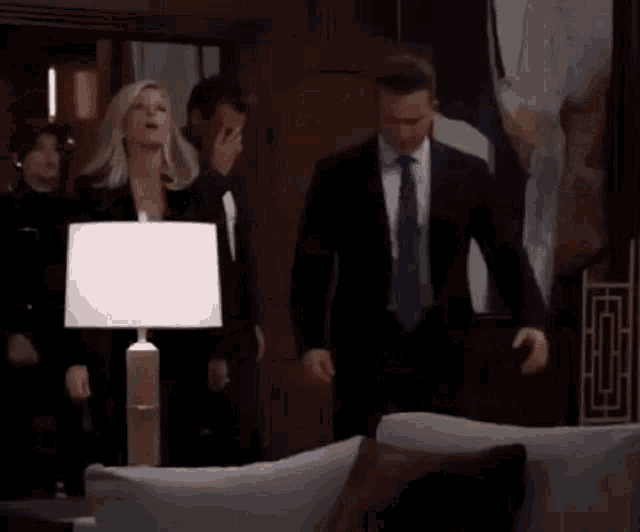 a group of people in suits are standing in a living room .
