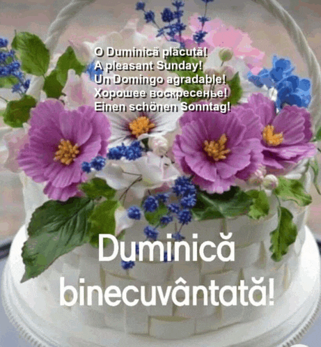 a cake with purple and blue flowers and the words duminica binecuvântata on it