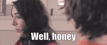 a woman is talking to a man in a kitchen and says `` well honey '' .