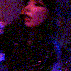 a woman singing in a dark room with chinese characters