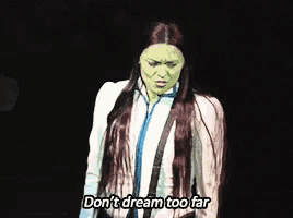 a woman in a green mask is saying " don 't dream too far "