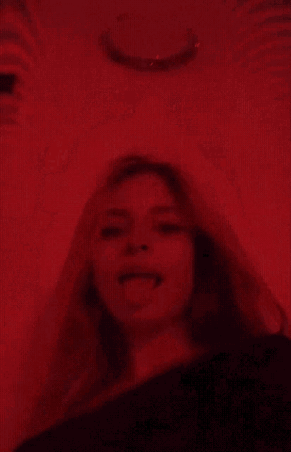 a woman sticking her tongue out in a dark room