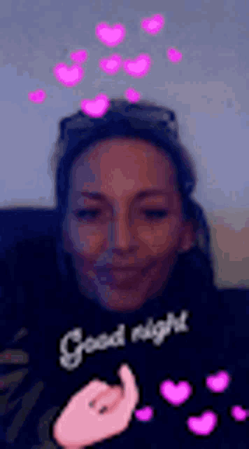 a woman is sitting on a couch with pink hearts coming out of her hair .