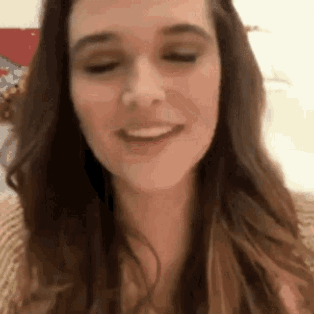 a close up of a woman 's face with her eyes closed and smiling .