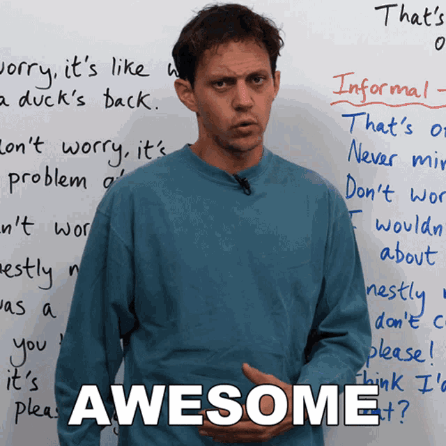 a man stands in front of a white board with the word awesome written on it