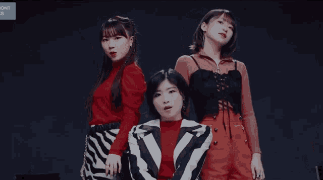 three asian girls are posing for a picture with a blue sign behind them that says ' icont '
