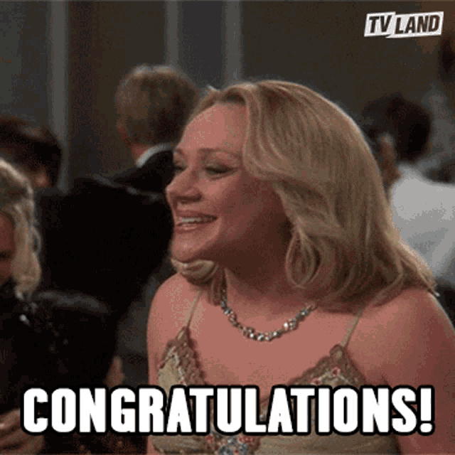 a woman is smiling and says congratulations in front of a crowd