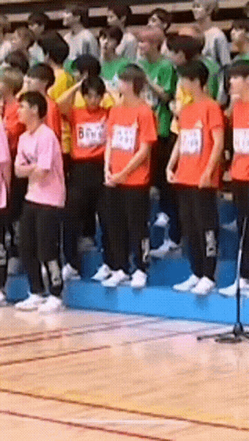 a group of people wearing orange shirts with numbers on them
