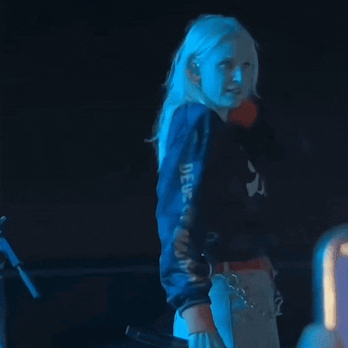 a woman giving the middle finger is wearing a blue jacket that says dg