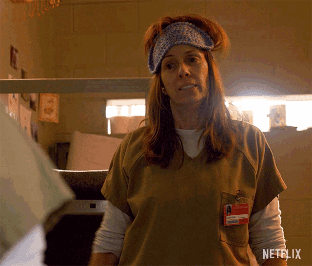 a woman wearing a netflix badge is standing in a room