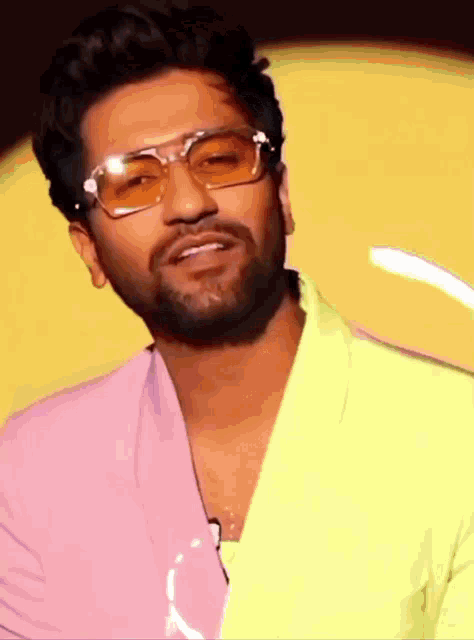 a man wearing sunglasses and a pink and yellow jacket