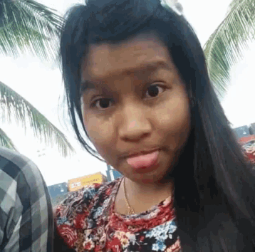 a girl sticking her tongue out and wearing a floral shirt